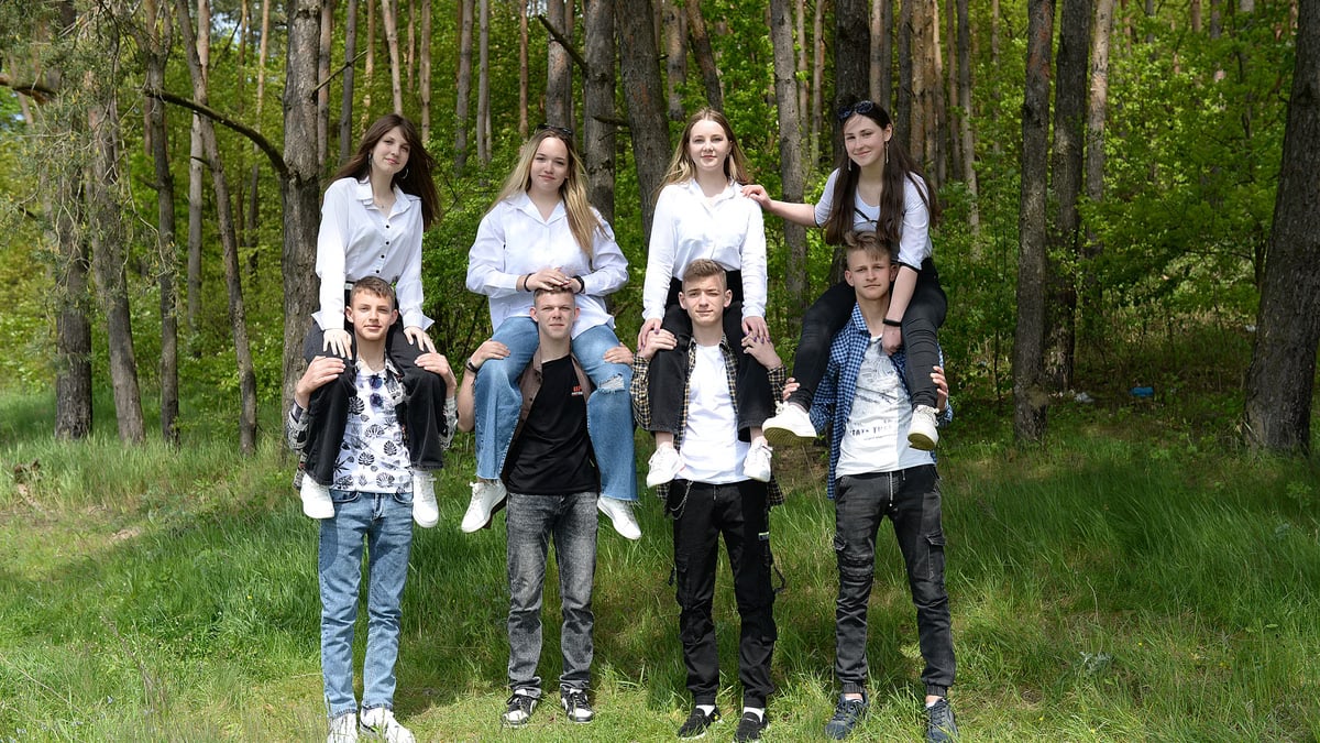 A group of friends having fun in a forest, enjoying nature and camaraderie on a sunny day.